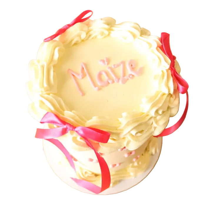 Vintage heart ribbon buttercream party cake with 'Maize' written on it.