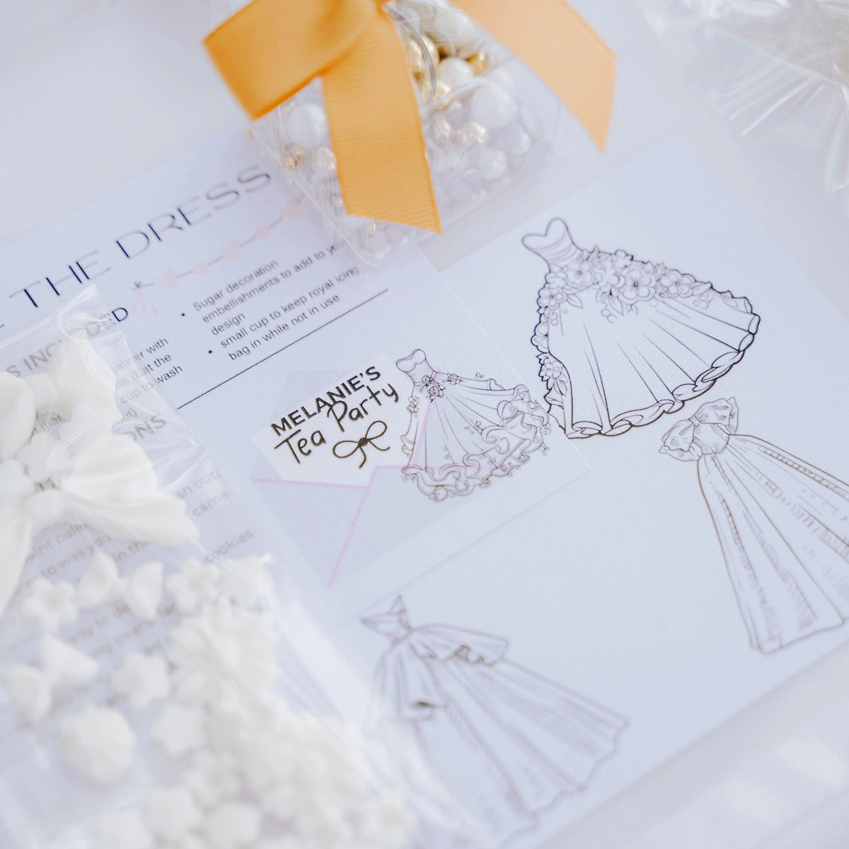 White bow decorations on a surface with text and illustrations of dresses.