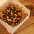 Dried fruit and nut mix in a decorative box on a wooden surface