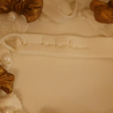 Decorative white box with gold ribbons and pearls on a blurred background