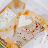 Heart-shaped white cookie in a decorative box with gold TMF ribbon 