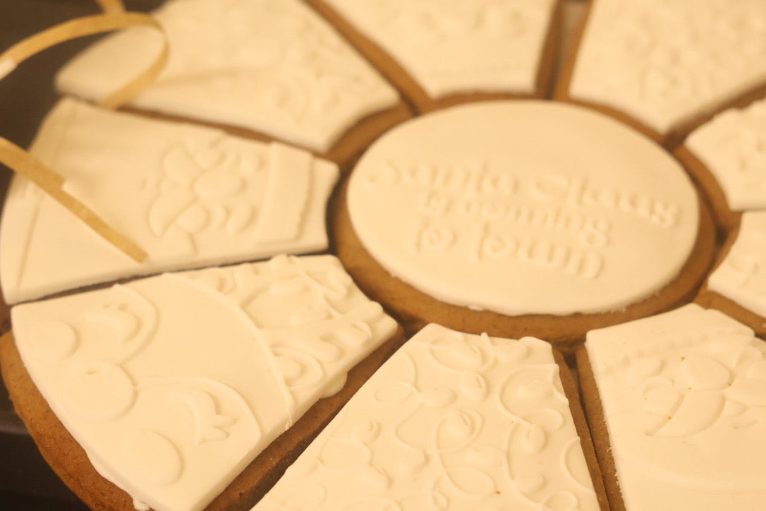 Close-up of a round cookie with embossed text and a central oval piece.