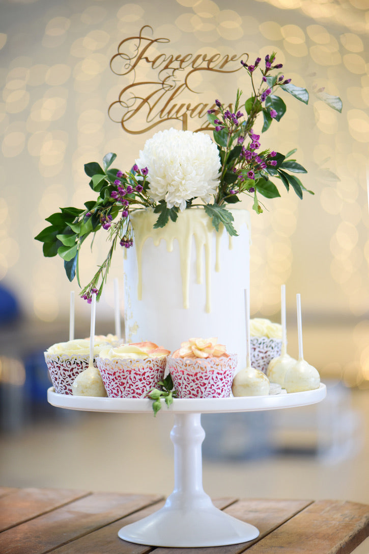 bespoke wedding cake with florals and a cake topper that reads 'Forever and Always'